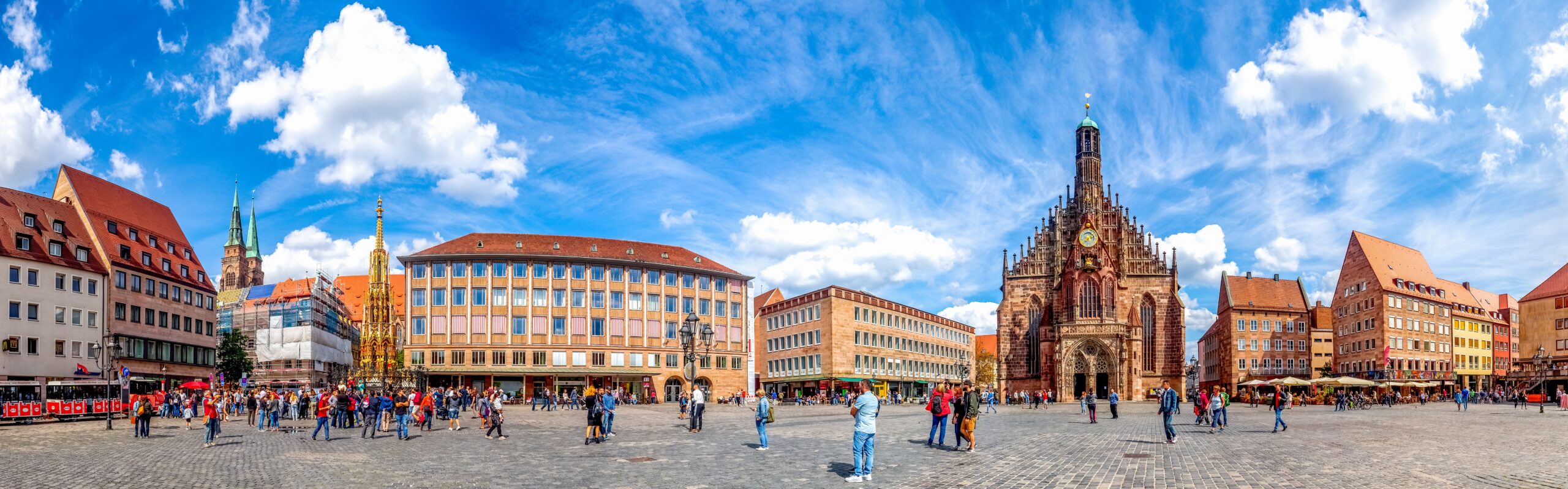 Blick auf den Hauptmarkt in Nürnberg mit der beeindruckenden Lorenzkirche und Menschenmenge. Climate Energy.