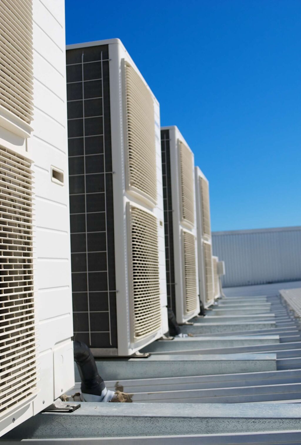 Reihe von Klimageräten auf einem Industriedach – mobile Mietkälte-Lösung für Gewerbe und Industrie