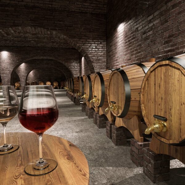 Ein Weinkeller mit Holzfässern und Gläsern auf einem Tisch. Ideal für 'Climate Energy'.