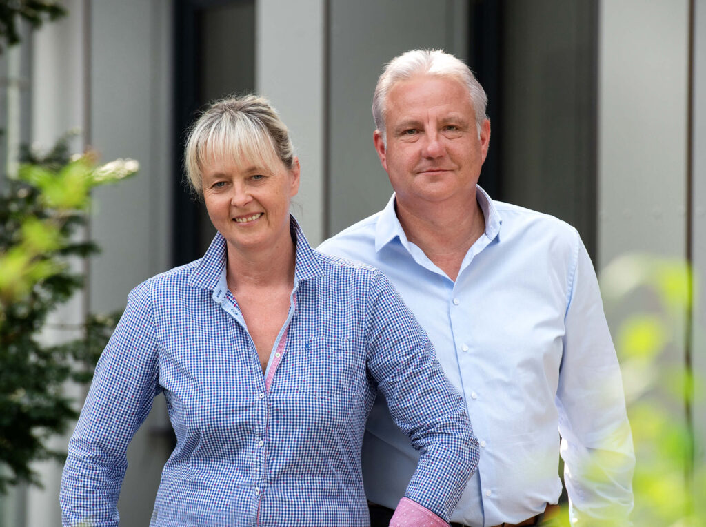 Zwei Personen vor einem Firmengebäude – Team der Geschäftsführung Climate Energy.