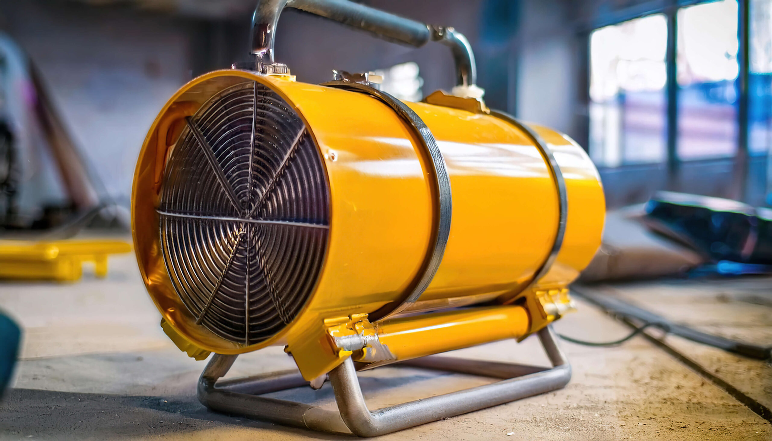 Gelber elektrischer Bauheizer in Industrieumgebung – effiziente mobile Wärme.