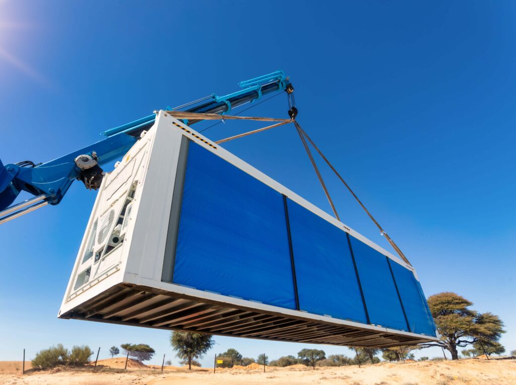 Kühlcontainer wird per Kran bewegt – flexible Mietkälte- und Klimaenergie-Lösung.
